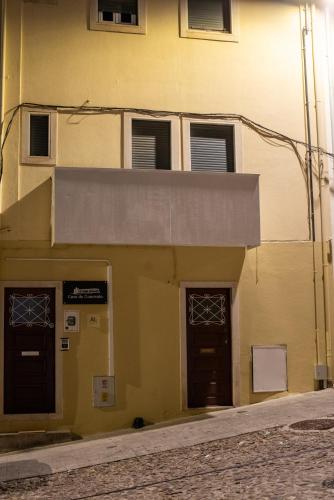 a yellow building with two doors and a balcony at Casa do Convento AL/141600 in Coimbra