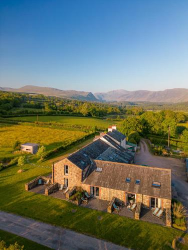 an aerial view of a farm house with mountains in the background at 1692 Wasdale in Gosforth