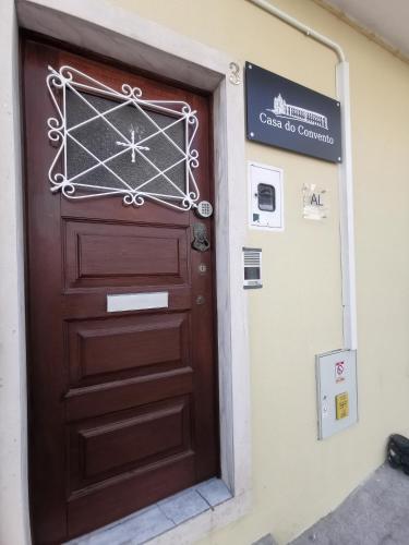a wooden door in a building with a sign on it at Casa do Convento AL/141600 in Coimbra
