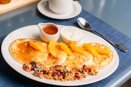 a plate of pancakes with fruit and syrup on a table at 1692 Wasdale in Gosforth