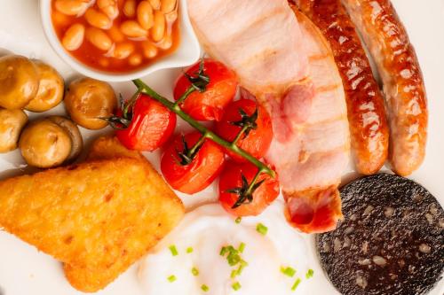 a plate of food with eggs bacon tomatoes and beans at 1692 Wasdale in Gosforth