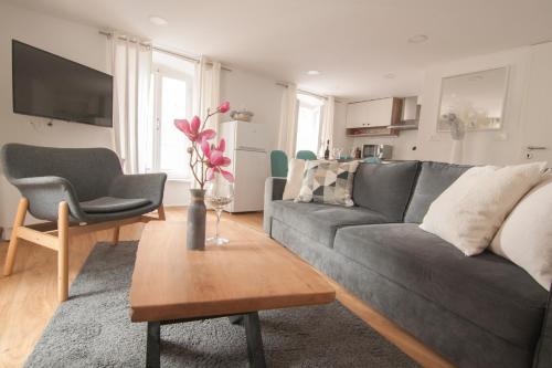 a living room with a gray couch and a table at Casa Porto in Piran