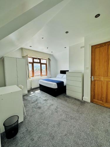 a bedroom with a bed and a wooden door at Blue rain in Hillingdon