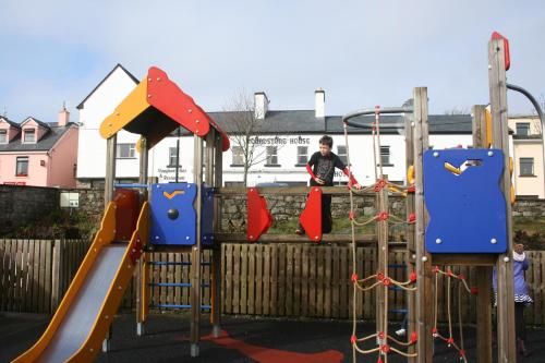 a boy is playing on a playground at Roundstone House Hotel in Roundstone