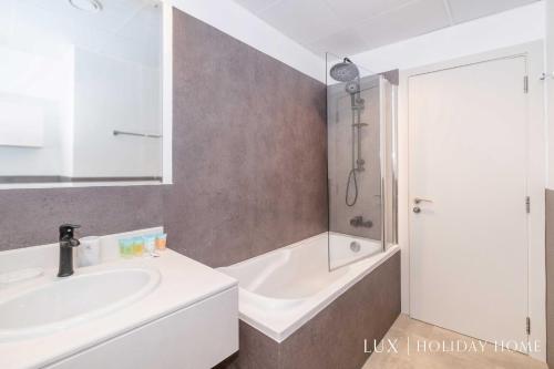 a bathroom with a tub and a sink and a shower at LUX The Luxurious Central JBR Suite in Dubai