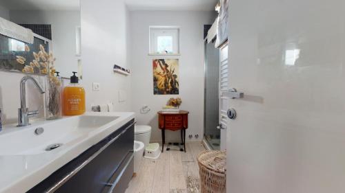 Baño blanco con lavabo y aseo en Villa Serena, en Viareggio