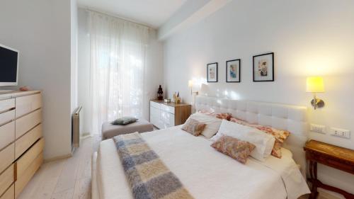 Habitación blanca con cama y TV en Villa Serena, en Viareggio