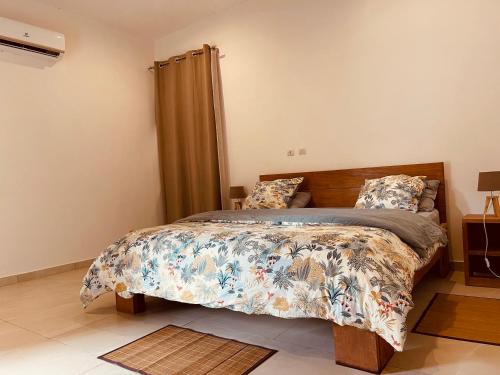 a bedroom with a bed with a comforter and pillows at Villa Assinie Bord de Lagune in Assinie
