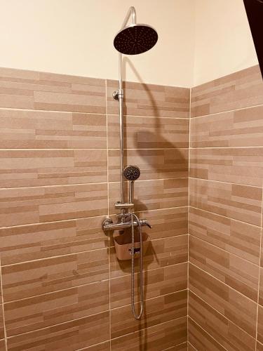 a bathroom with a shower with a shower head at Villa Assinie Bord de Lagune in Assinie