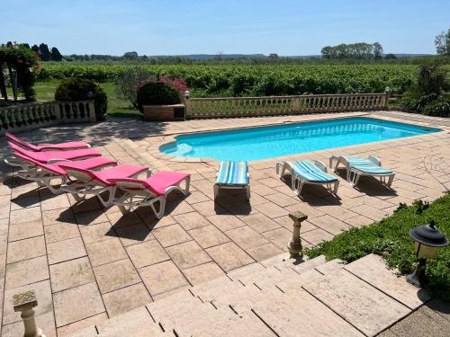 une piscine avec des chaises longues et une piscine dans l'établissement Domaine de Favette, à Coursan