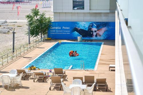 una piscina con 2 personas en el agua en CAELIA Residence ap 2 camere en Mamaia
