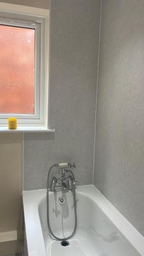 eine Badewanne im Bad mit Fenster in der Unterkunft Serenity Station in Hornsea
