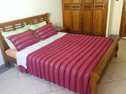 una camera da letto con un grande letto con una coperta rosa di location de vacance sidi bouzid a Sidi Bouzid