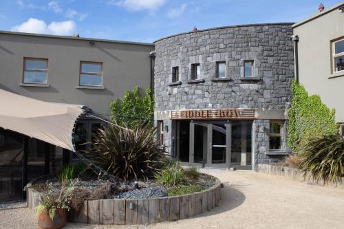 un edificio in pietra con un cartello che legge il crinale del patrimonio di Fiddle + Bow Hotel a Doolin