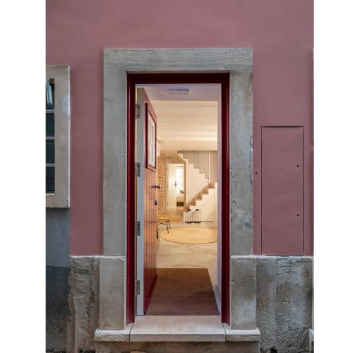 a doorway into a hallway with a pink wall at Loureiro 59 in Coimbra