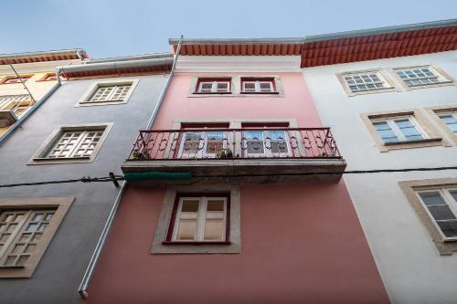 a pink building with a balcony at Loureiro 59 in Coimbra