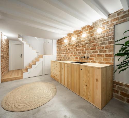 a bathroom with a sink and a brick wall at Loureiro 59 in Coimbra