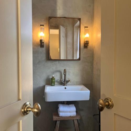 a bathroom with a white sink and a mirror at Fiddle + Bow Hotel in Doolin
