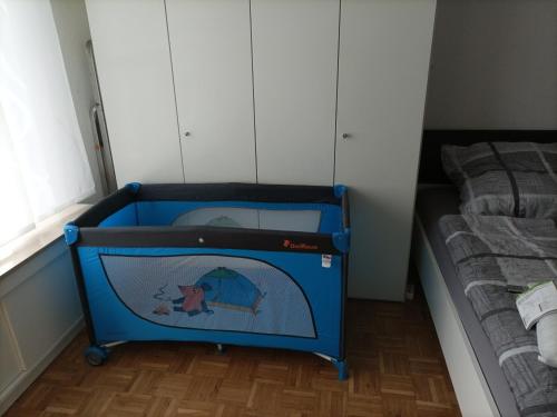 ein blaues Kinderbett in einem Schlafzimmer neben einem Bett in der Unterkunft Willy und Gudrun in Rheda-Wiedenbrück