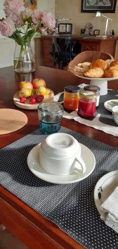 uma mesa com um copo e pratos de comida em Maison blanche em Cherval