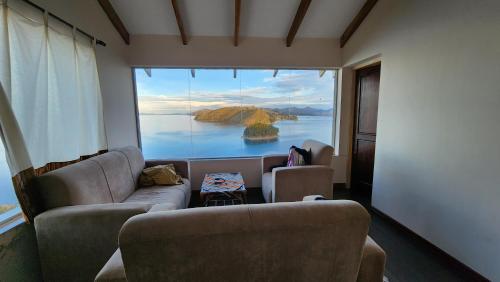 - un salon avec vue sur une grande fenêtre dans l'établissement Inti Illimani Lodge, à Comunidad Yumani