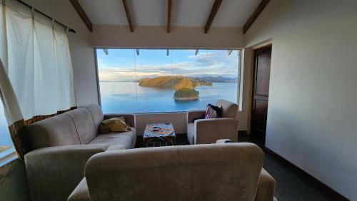a living room with a view of a large window at Inti Illimani Lodge in Comunidad Yumani