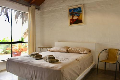 a bedroom with a bed with towels on it at Marina Bungalows in Los Órganos