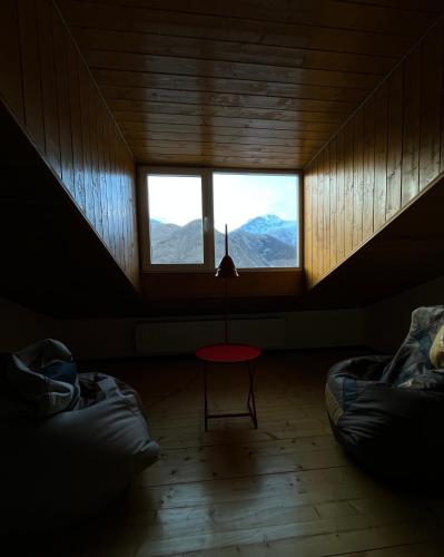 a room with two beds and a window with mountains at Mansarda Kazbegi in Stepantsminda
