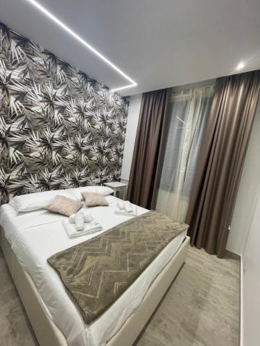 a bedroom with a large white bed and a wall at Bobbio Holiday Rome in Rome