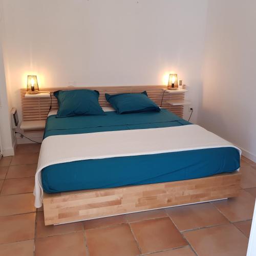 une chambre avec un grand lit avec des oreillers bleus dans l'établissement Petite Villa indépendante - Grande piscine 12x8, à Carqueiranne