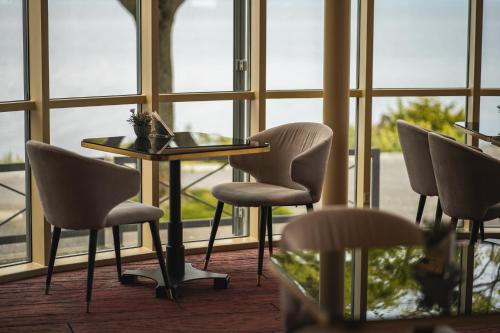 a table and chairs in a room with windows at Beau Rivage Hotel in Neuchâtel