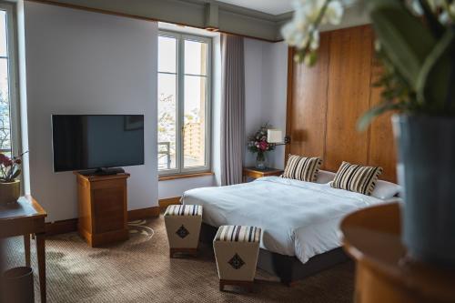 a hotel room with a bed and a flat screen tv at Beau Rivage Hotel in Neuchâtel