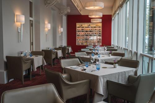a row of tables in a restaurant with red walls at Beau Rivage Hotel in Neuchâtel