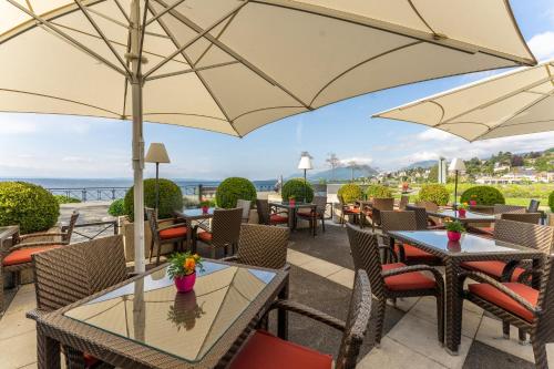 a patio at a restaurant with tables and umbrellas at Beau Rivage Hotel in Neuchâtel