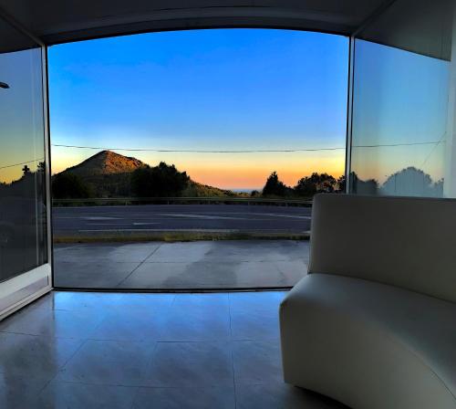 a room with a window with a couch and a view at Area Surf House in Muros