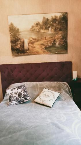 un livre assis au-dessus d'un lit avec un tableau dans l'établissement Liloye, à Bagnères-de-Bigorre