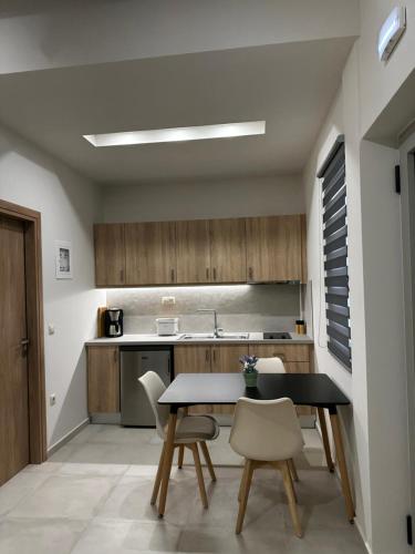 a kitchen with a table and chairs in a room at Aktaion Rooms in Stoupa