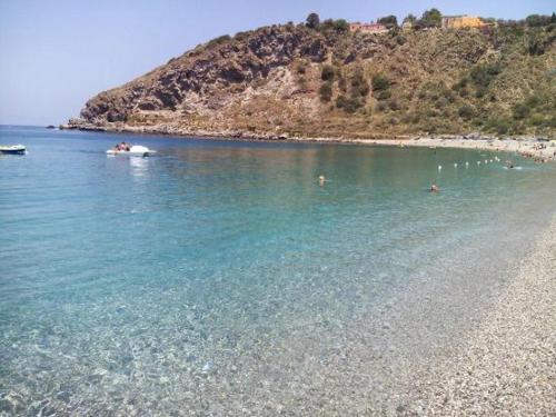 a group of people in the water on a beach at Casa Vacanza - La Tartaruga in Milazzo