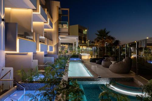 un edificio con piscina por la noche en Pearl SeaBreeze Suites en Rethymno
