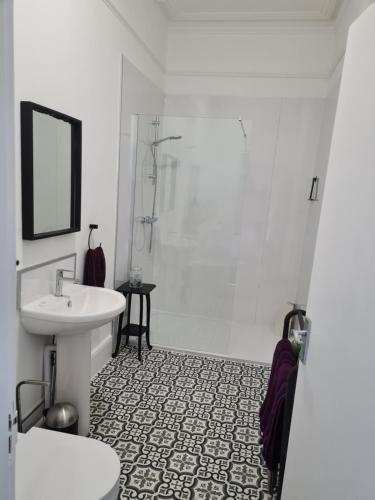 a white bathroom with a shower and a sink at Gorgeous Sea View Apartment 5 mins To The Beach in St. Leonards