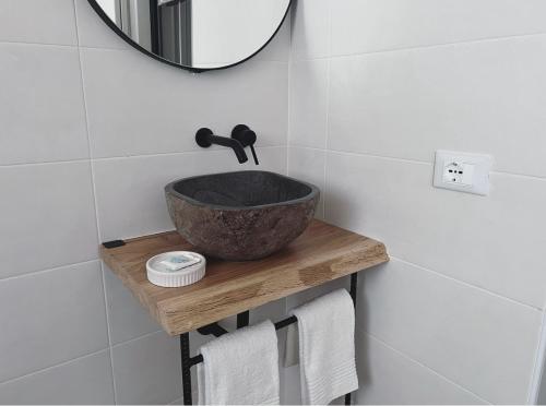 a bathroom with a bowl sink and a mirror at Casa Amapola in Follonica