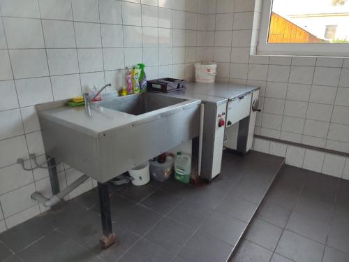 eine Küche mit einem Waschbecken in einem gefliesten Zimmer in der Unterkunft Soukromé pokoje s klubovnou a zahradou in Slezské Pavlovice