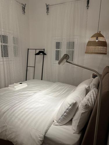 a bedroom with a large white bed with a lamp at Dar Sayang in Taif