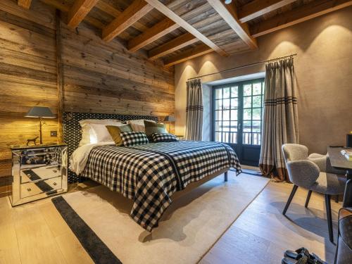 ein Schlafzimmer mit einem Bett in einem Zimmer mit Holzwänden in der Unterkunft Superbe ferme rénovée en chalet de luxe en PLEINE NATURE in Barcelonnette