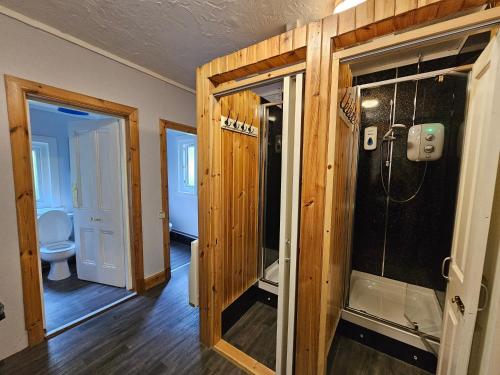 a bathroom with a shower and a toilet in a room at West Highland Lodge in Kinlochleven