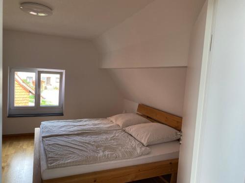Bett in einem Zimmer mit Fenster in der Unterkunft Am Brunnen in Überlingen