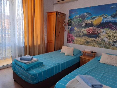 a bedroom with two beds and a painting on the wall at Morska Zvezda Guest house in Pomorie