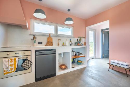 a kitchen with pink walls and a dishwasher at Water Views Casa Wan in Aljezur