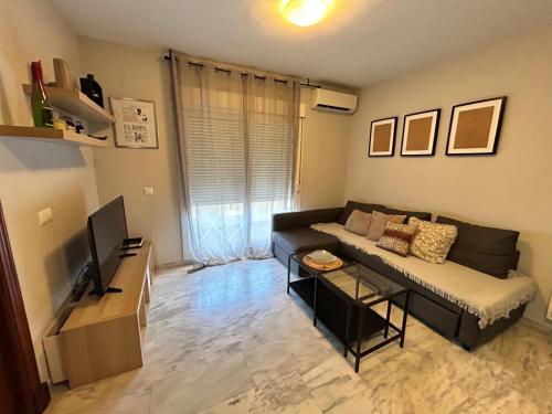 a living room with a couch and a television at Apartamento Atico Algeciras in Algeciras
