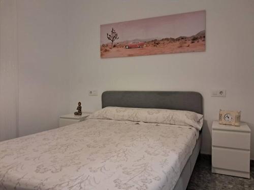 a bedroom with a bed and a painting on the wall at Altamira White & Bright in Almería